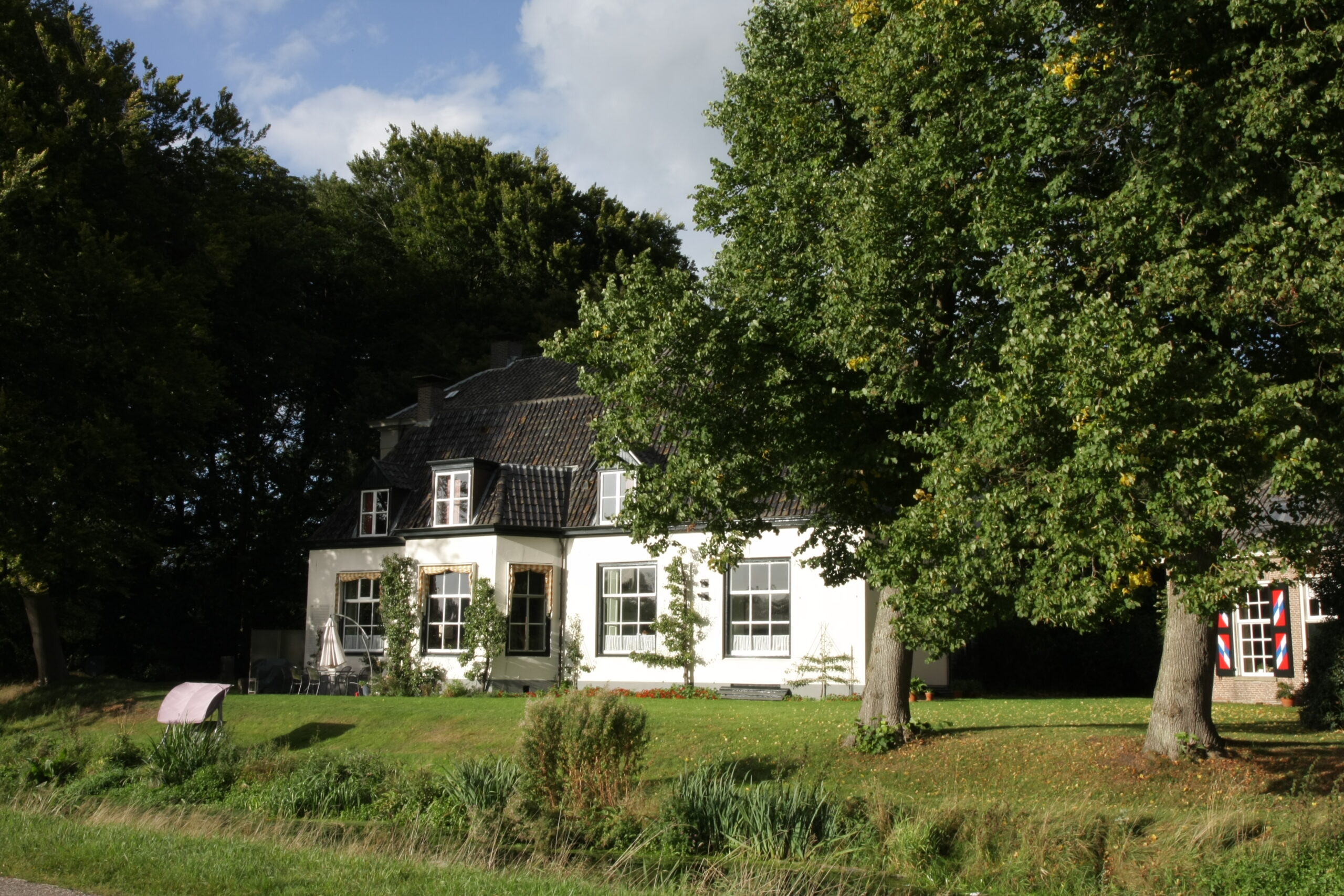 Een van de gebouwen op de buitenplaats, gezien over het weiland.