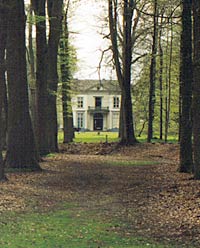 Het landhuis tussen de bomen van het park.